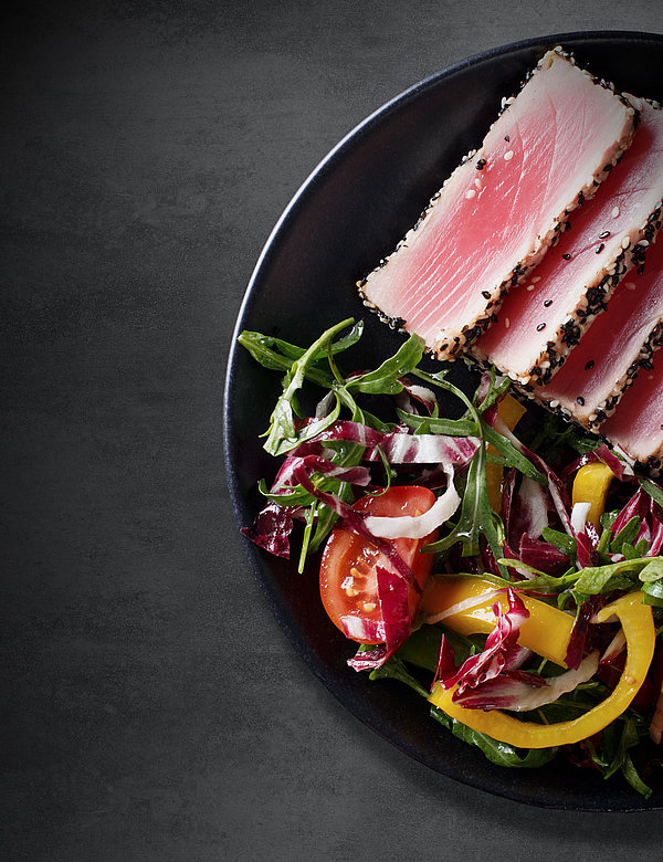 Pepper-crusted tuna on a bed of salad